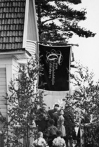 Juhannusjuhlissa yhdistyksen lippu kunniapaikalla ja juhlijoilla 'kovat kaulassa'